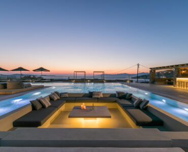 Pool lounge and pool bar at dusk at Villa Arion in Aleomandra, Mykonos