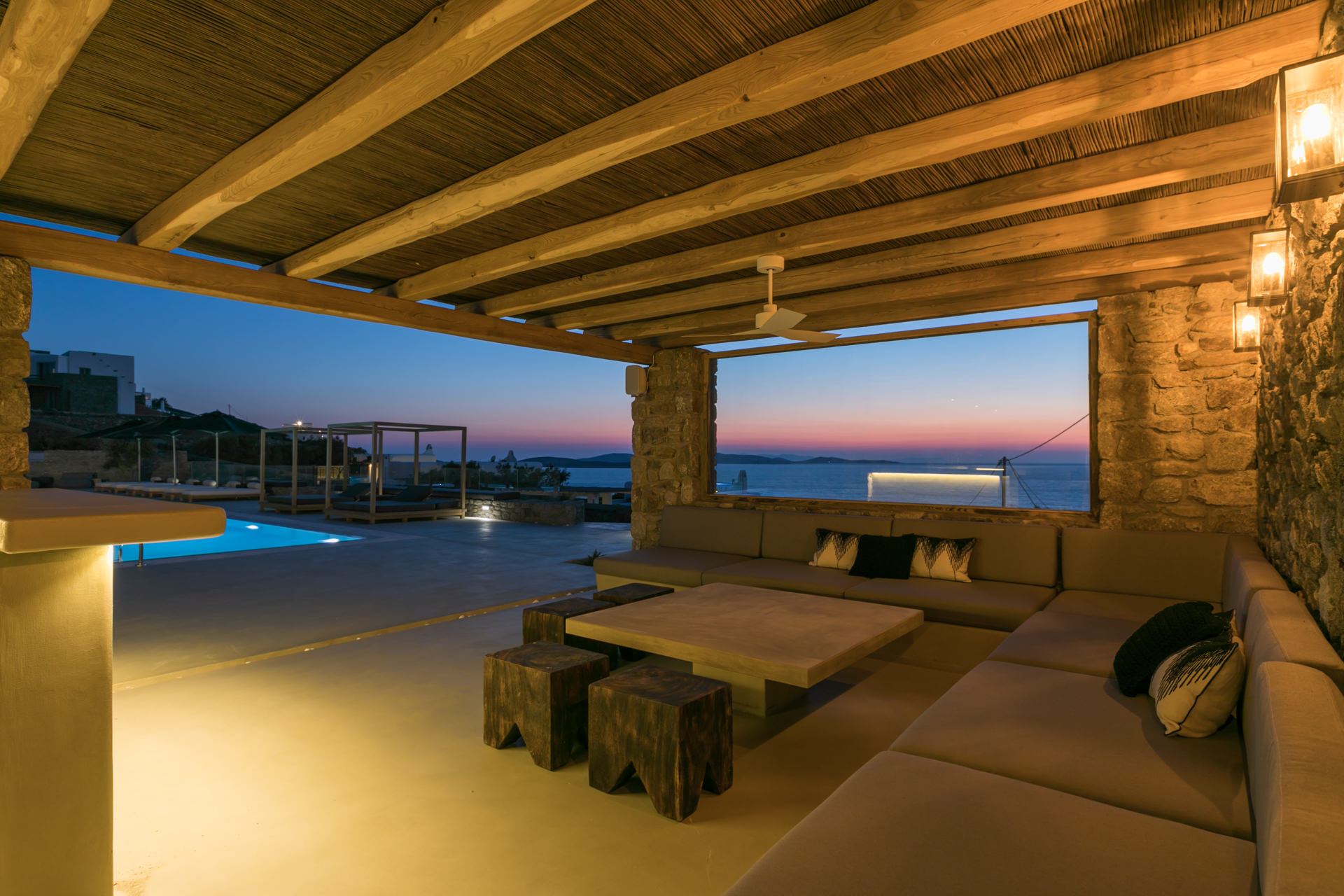 Covered lounge at dusk with sea view at Villa Arion in Aleomandra, Mykonos