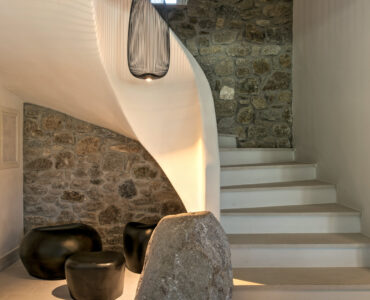 Curved staircase with stone wall at Villa Arion in Aleomandra, Mykonos