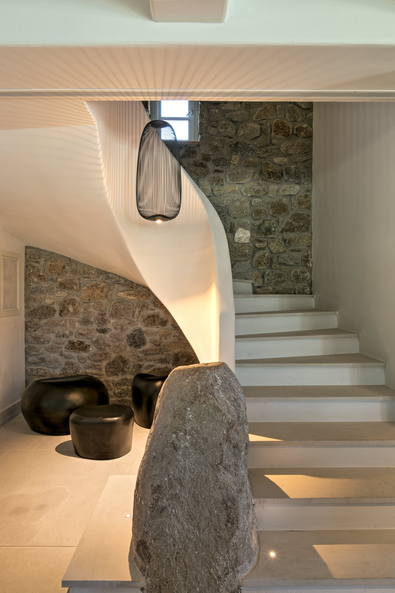Curved staircase with stone wall at Villa Arion in Aleomandra, Mykonos