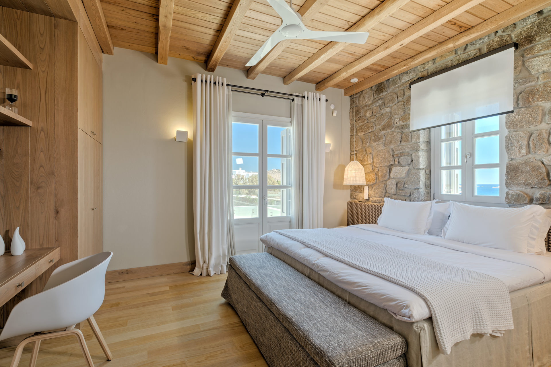 Master bedroom with stone wall at Villa Arion in Aleomandra, Mykonos