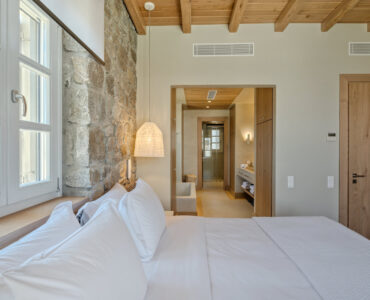 Master bedroom with sea-view windows at Villa Arion in Aleomandra, Mykonos