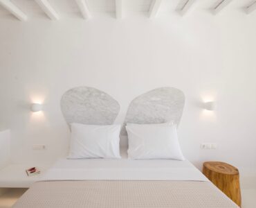 Bedroom with sculpted headboard at Villa Costa in Elia, Mykonos