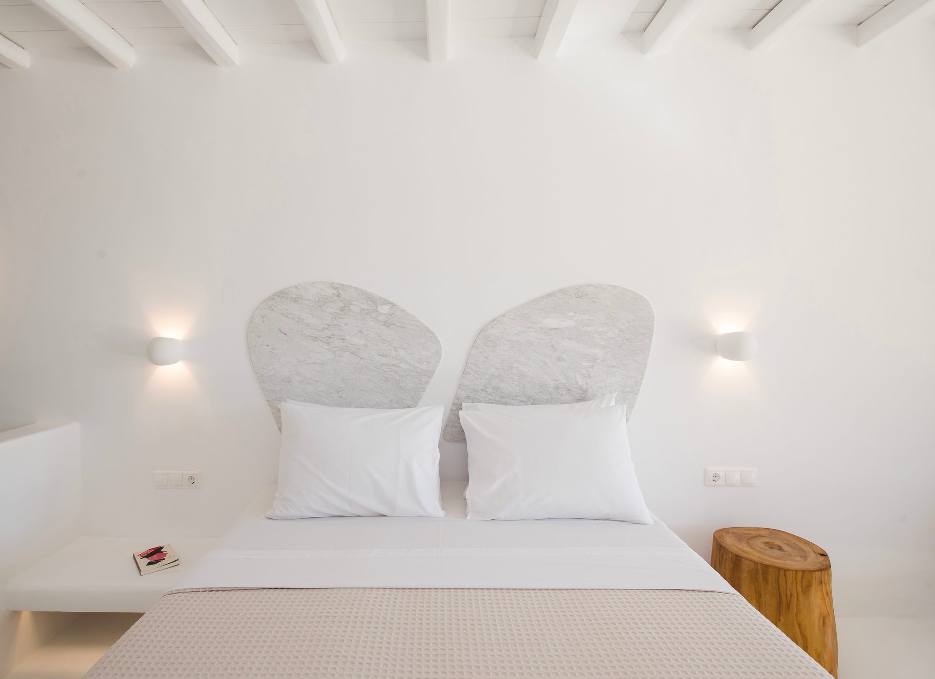 Bedroom with sculpted headboard at Villa Costa in Elia, Mykonos