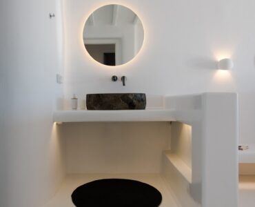 Bathroom with round mirror at Villa Costa in Elia, Mykonos