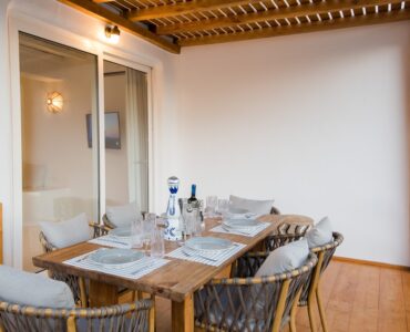 Dining area under the wooden ceiling at Villa Costa in Elia, Mykonos