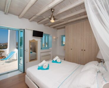 Bedroom with canopy bed and terrace door at Villa Danelina in Agios Lazaros, Mykonos