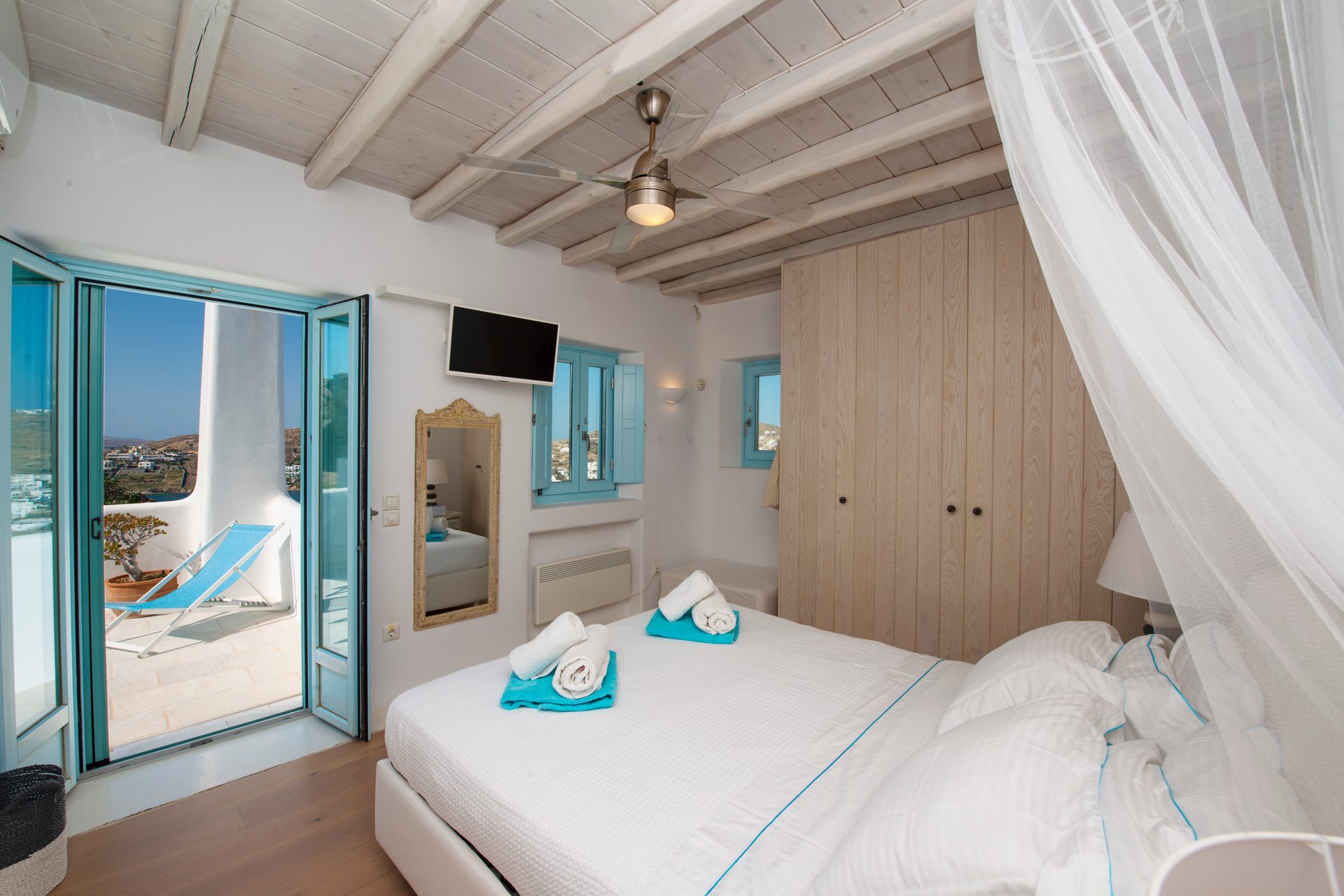 Bedroom with canopy bed and terrace door at Villa Danelina in Agios Lazaros, Mykonos