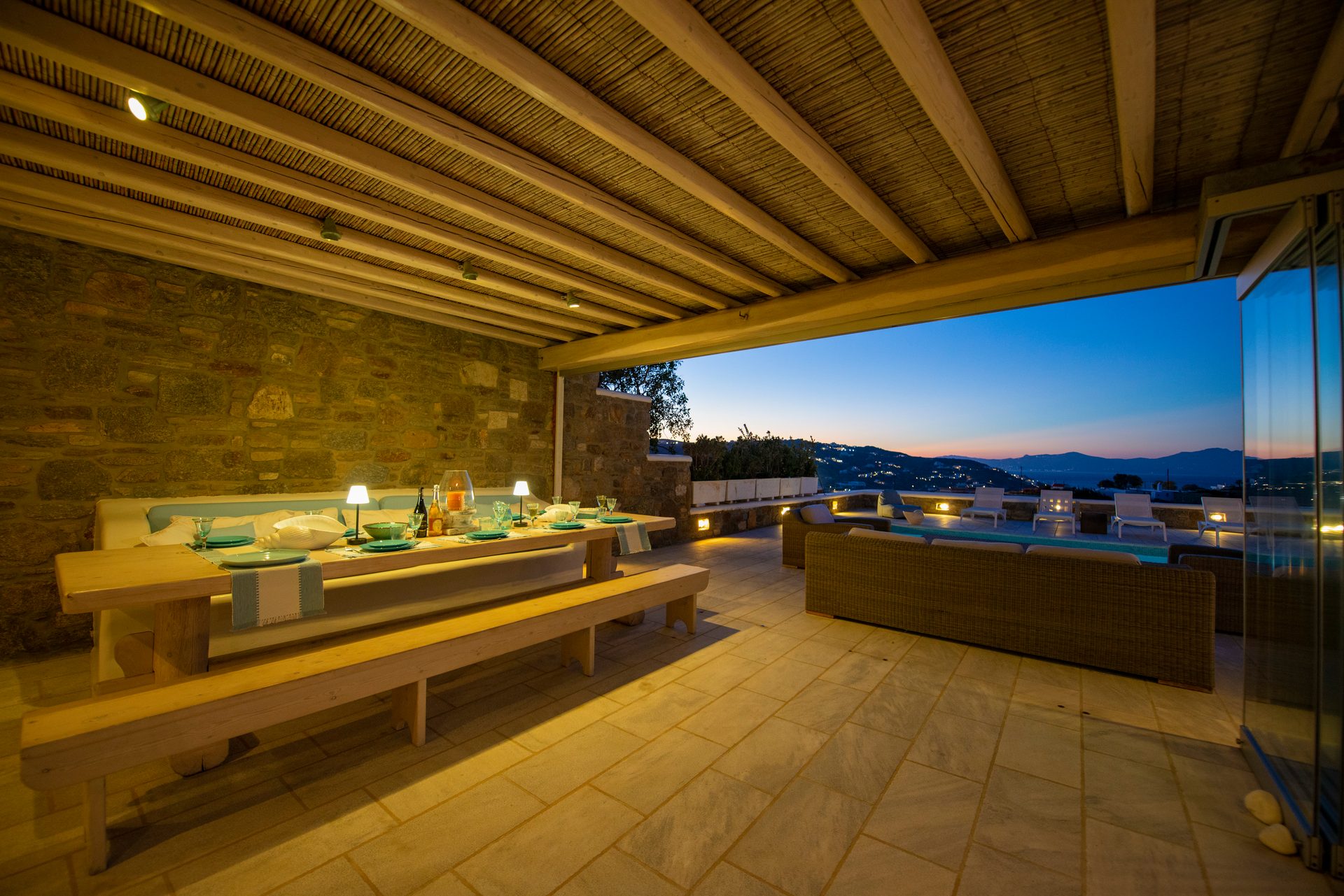 Covered dining terrace at dusk at Villa Danelina in Agios Lazaros, Mykonos