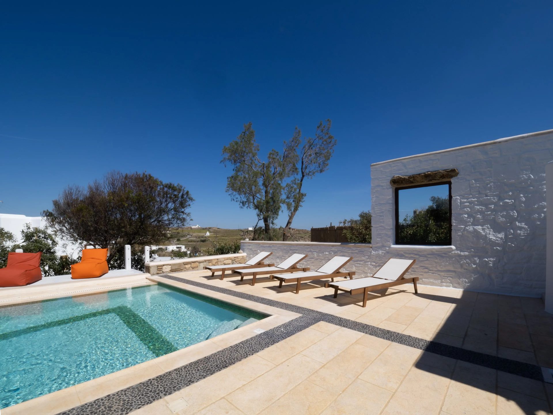 Pool with sun loungers at Villa Gaia in Psarou, Mykonos