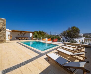 Pool terrace with sun loungers at Villa Gaia in Psarou, Mykonos