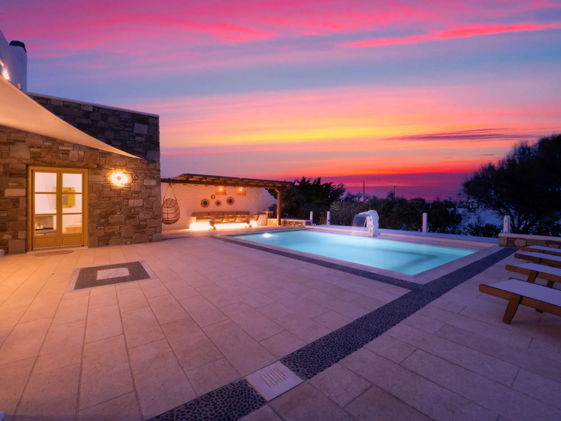 Pool terrace at dusk at Villa Gaia in Psarou, Mykonos