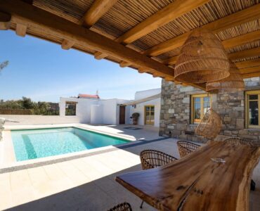 Pool seen from the shaded pergola at Villa Gaia in Psarou, Mykonos