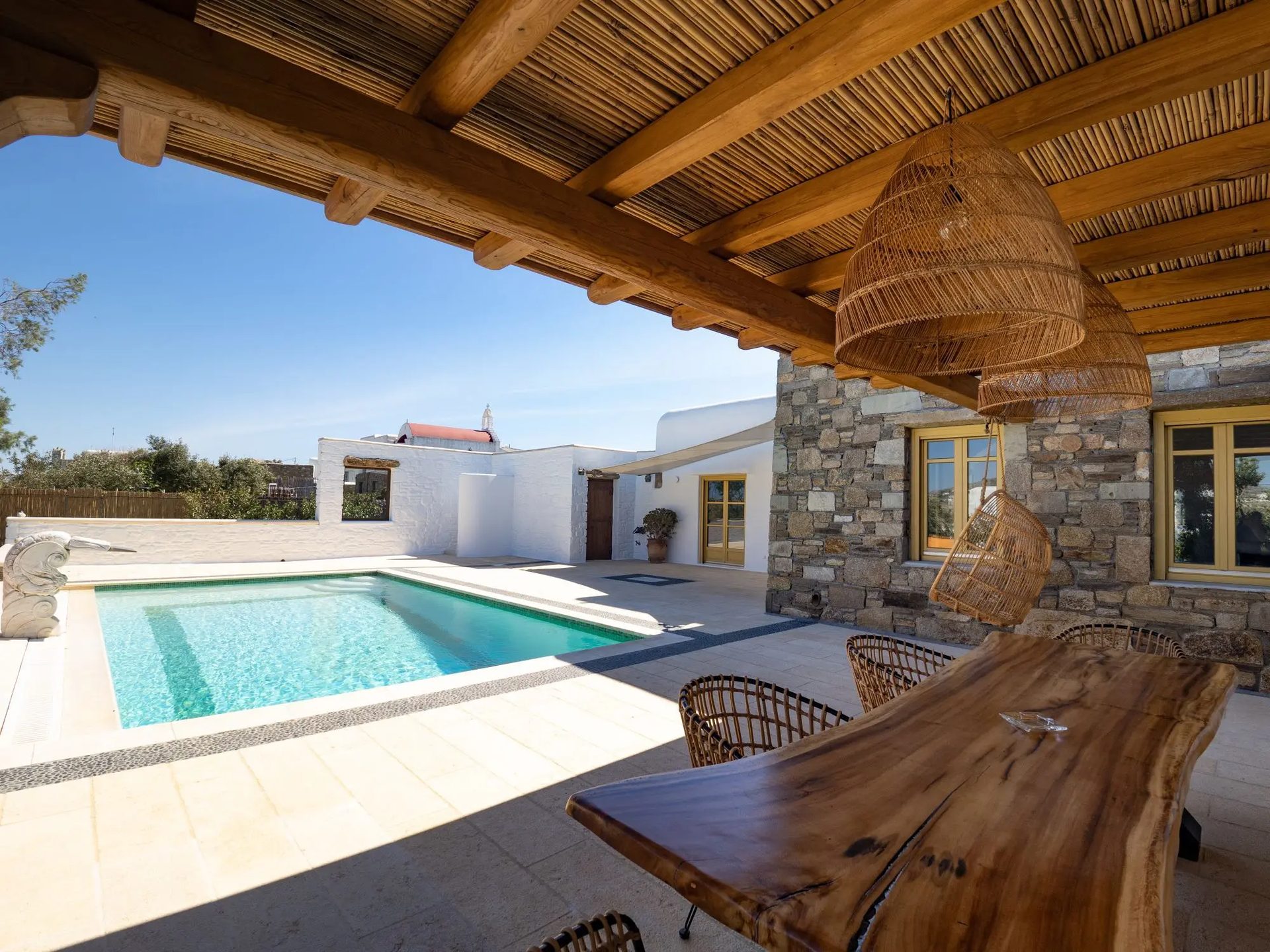 Pool seen from the shaded pergola at Villa Gaia in Psarou, Mykonos