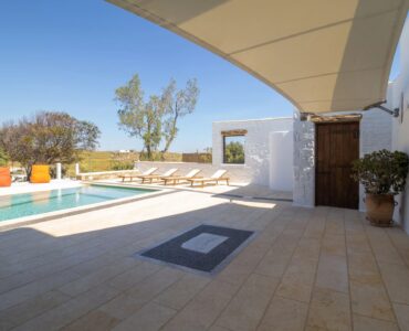 Shaded terrace with pool views at Villa Gaia in Psarou, Mykonos