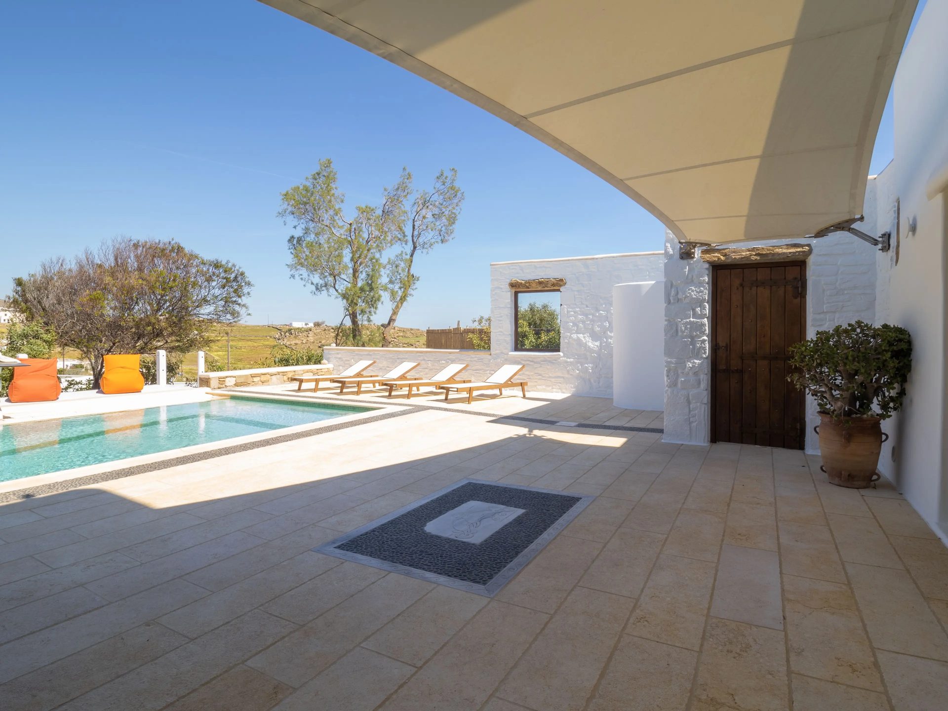 Shaded terrace with pool views at Villa Gaia in Psarou, Mykonos