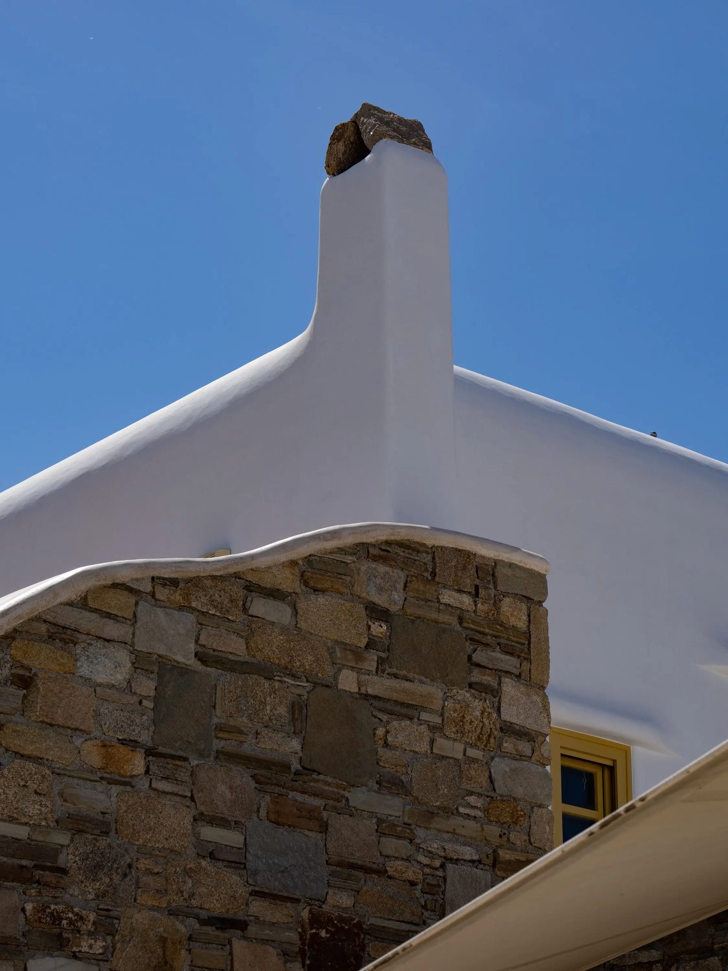 Cycladic chimney and stone wall at Villa Gaia in Psarou, Mykonos