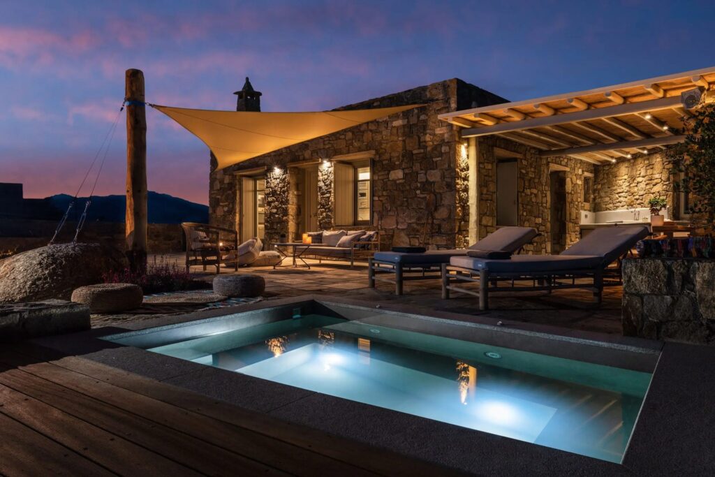 Private heated jacuzzi and deck at dusk at Villa Kele in Ftelia, Mykonos