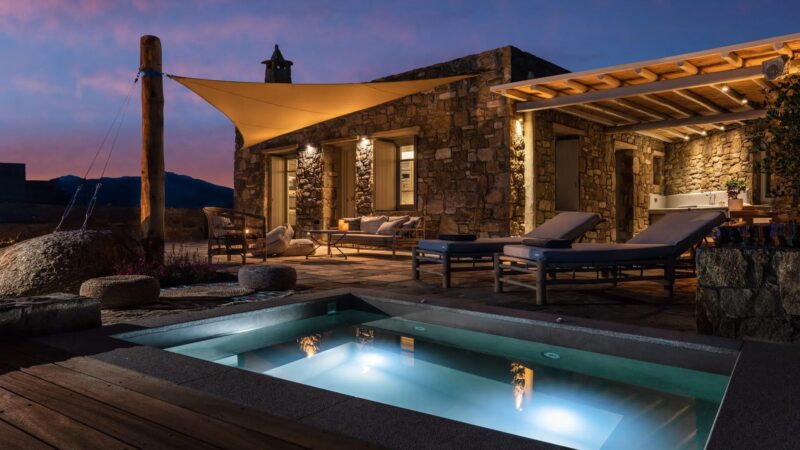 Private heated jacuzzi and deck at dusk at Villa Kele in Ftelia, Mykonos