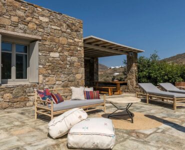 Stone terrace with lounge and sun loungers at Villa Kele in Ftelia, Mykonos