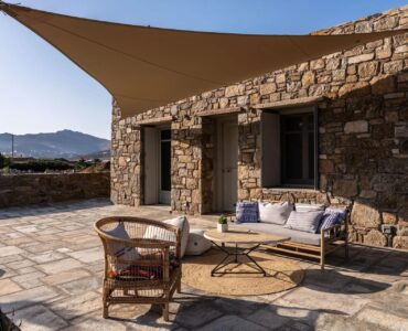 Shaded terrace lounge with sea views at Villa Kele in Ftelia, Mykonos