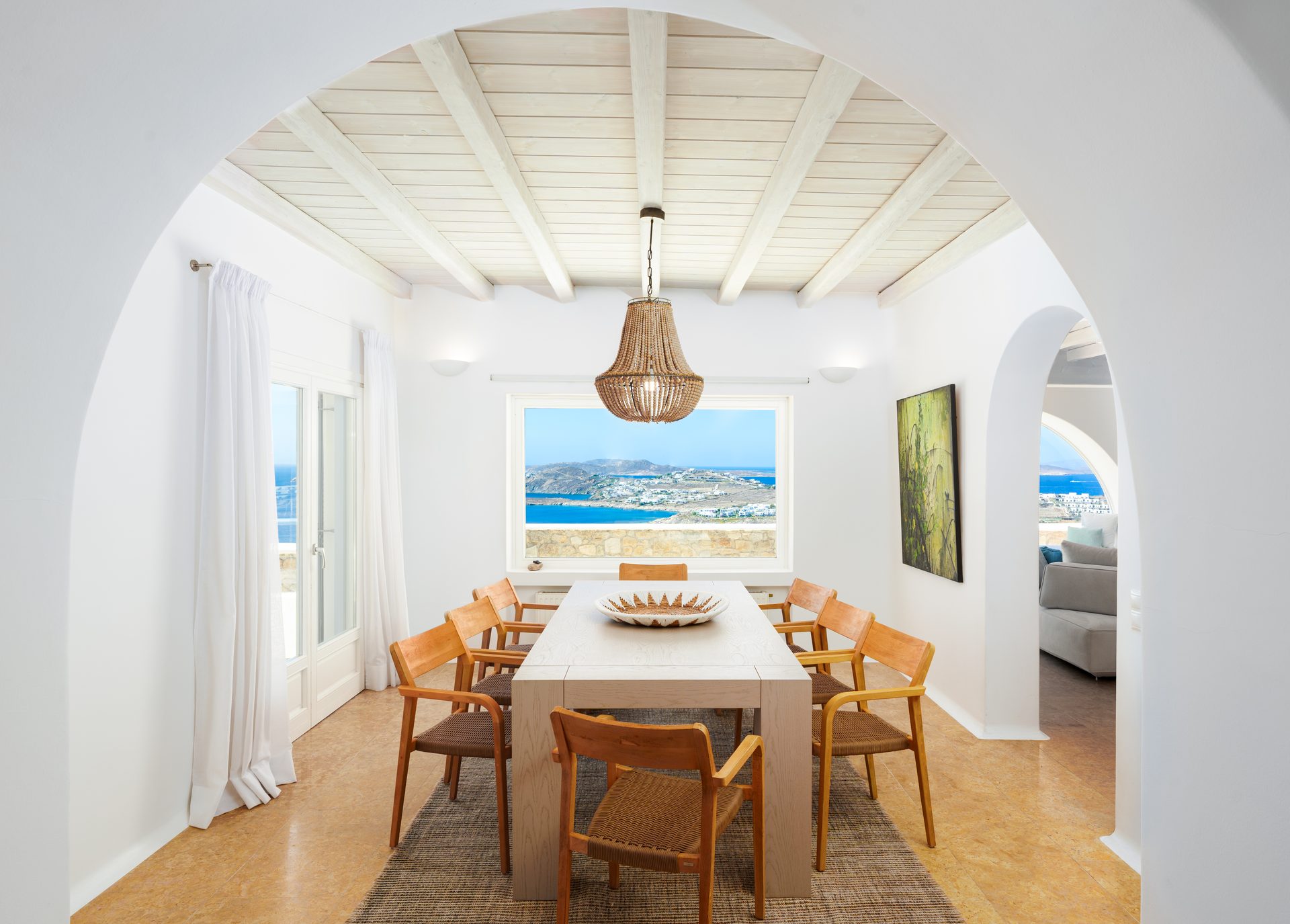 Dining room with arched window at Villa Kymothea in Agios Lazaros, Mykonos