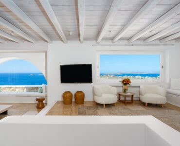 Living room with arched sea-view windows at Villa Kymothea in Agios Lazaros, Mykonos