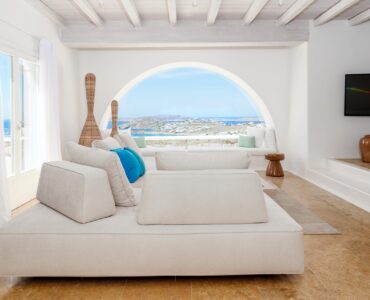 Lounge with arched sea-view window at Villa Kymothea in Agios Lazaros, Mykonos
