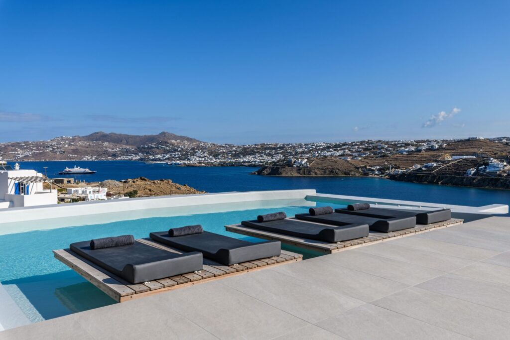 Infinity pool with in-pool sun loungers and sea view at Villa Nerovino in Kanalia, Mykonos