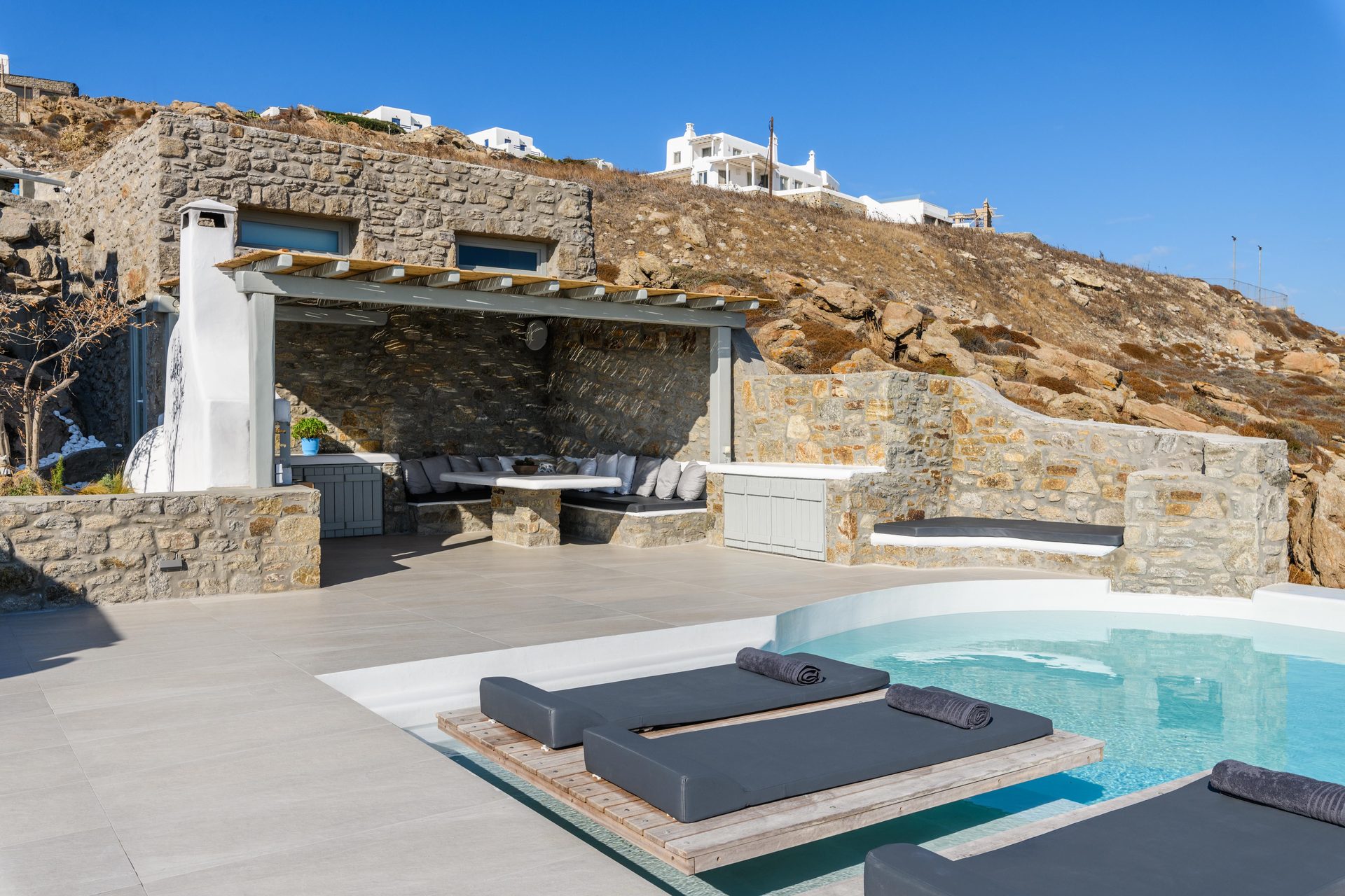 Pool terrace and covered lounge at Villa Nerovino in Kanalia, Mykonos