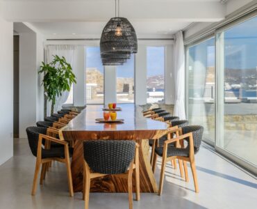 Dining area with panoramic windows at Villa Nerovino in Kanalia, Mykonos