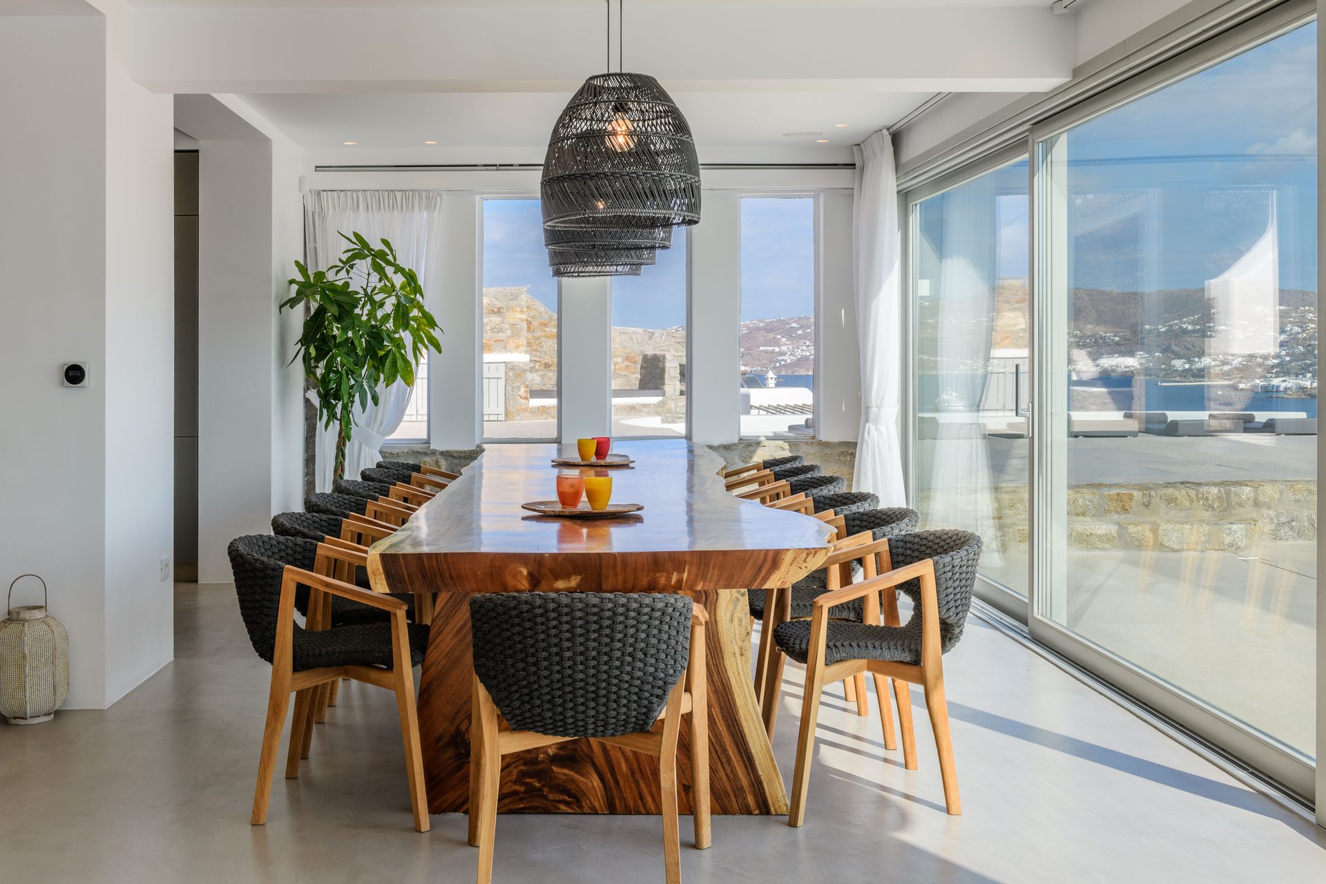 Dining area with panoramic windows at Villa Nerovino in Kanalia, Mykonos