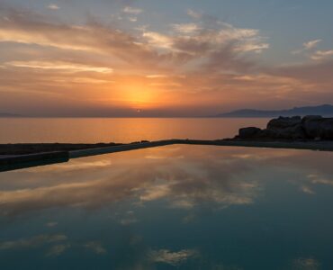 Sunset reflected in the pool at Villa Pergisos in Kanalia, Mykonos