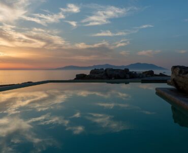 Sunset over the sea from the pool at Villa Pergisos in Kanalia, Mykonos