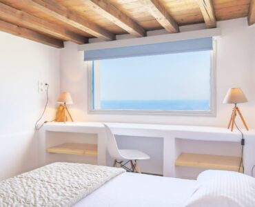 Bedroom with panoramic window at Villa Phaedra in Pouli, Mykonos