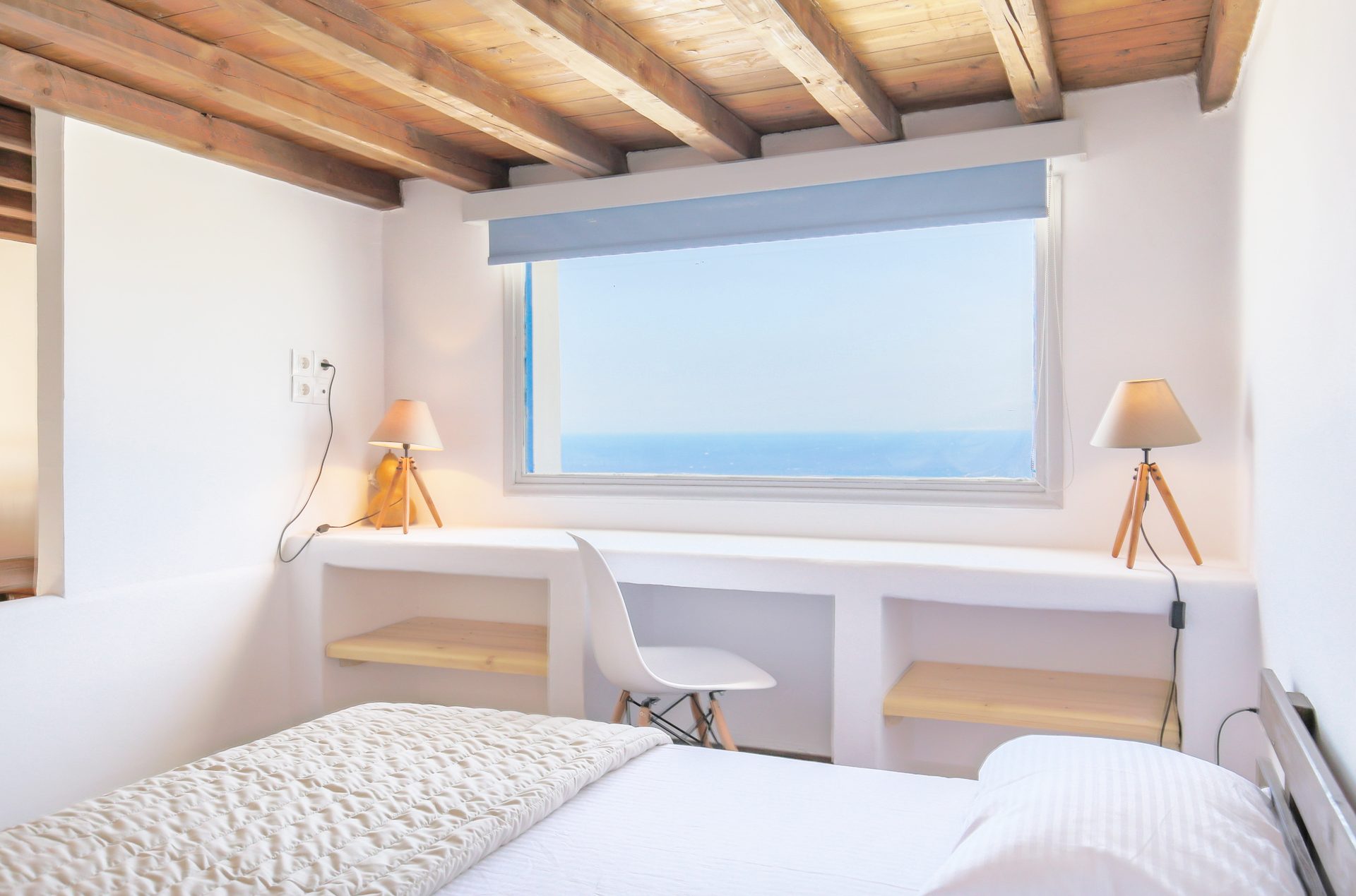 Bedroom with panoramic window at Villa Phaedra in Pouli, Mykonos