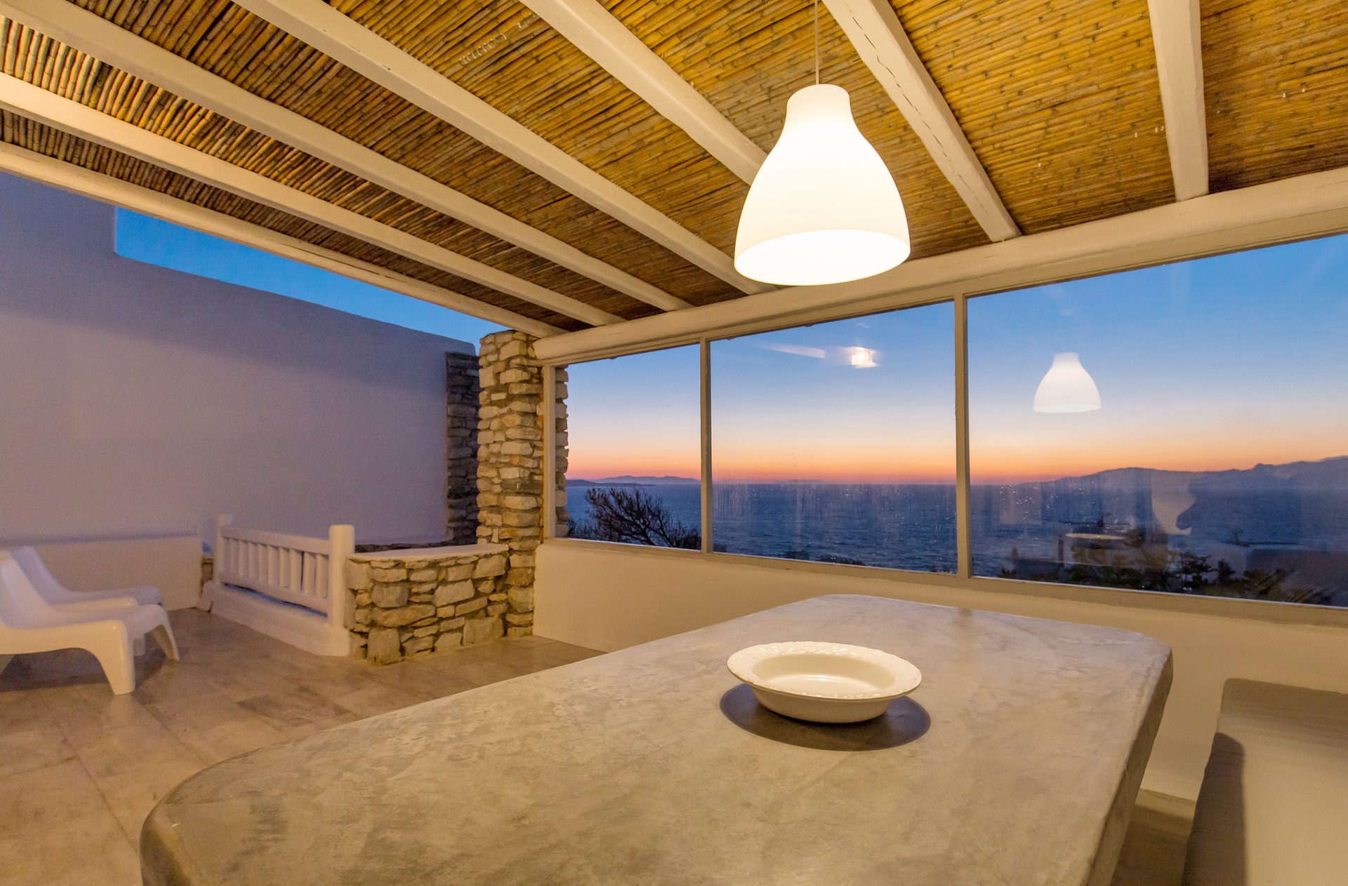 Sea-view dining room at sunset at Villa Phaedra in Pouli, Mykonos