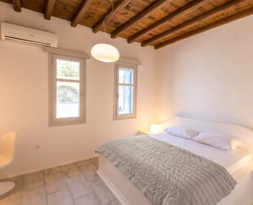 Double bedroom with wooden beams at Villa Phaedra in Pouli, Mykonos