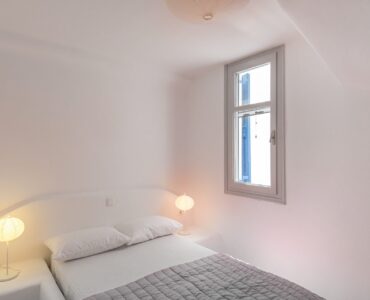 Bedroom with bedside lamps at Villa Phaedra in Pouli, Mykonos