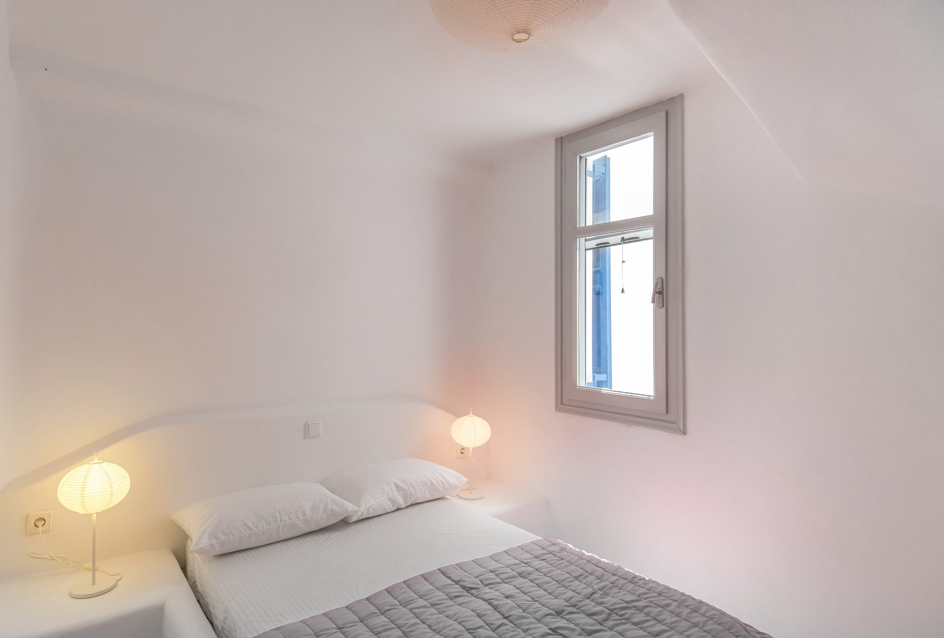 Bedroom with bedside lamps at Villa Phaedra in Pouli, Mykonos