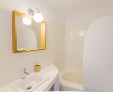 Bathroom with round mirror at Villa Phaedra in Pouli, Mykonos