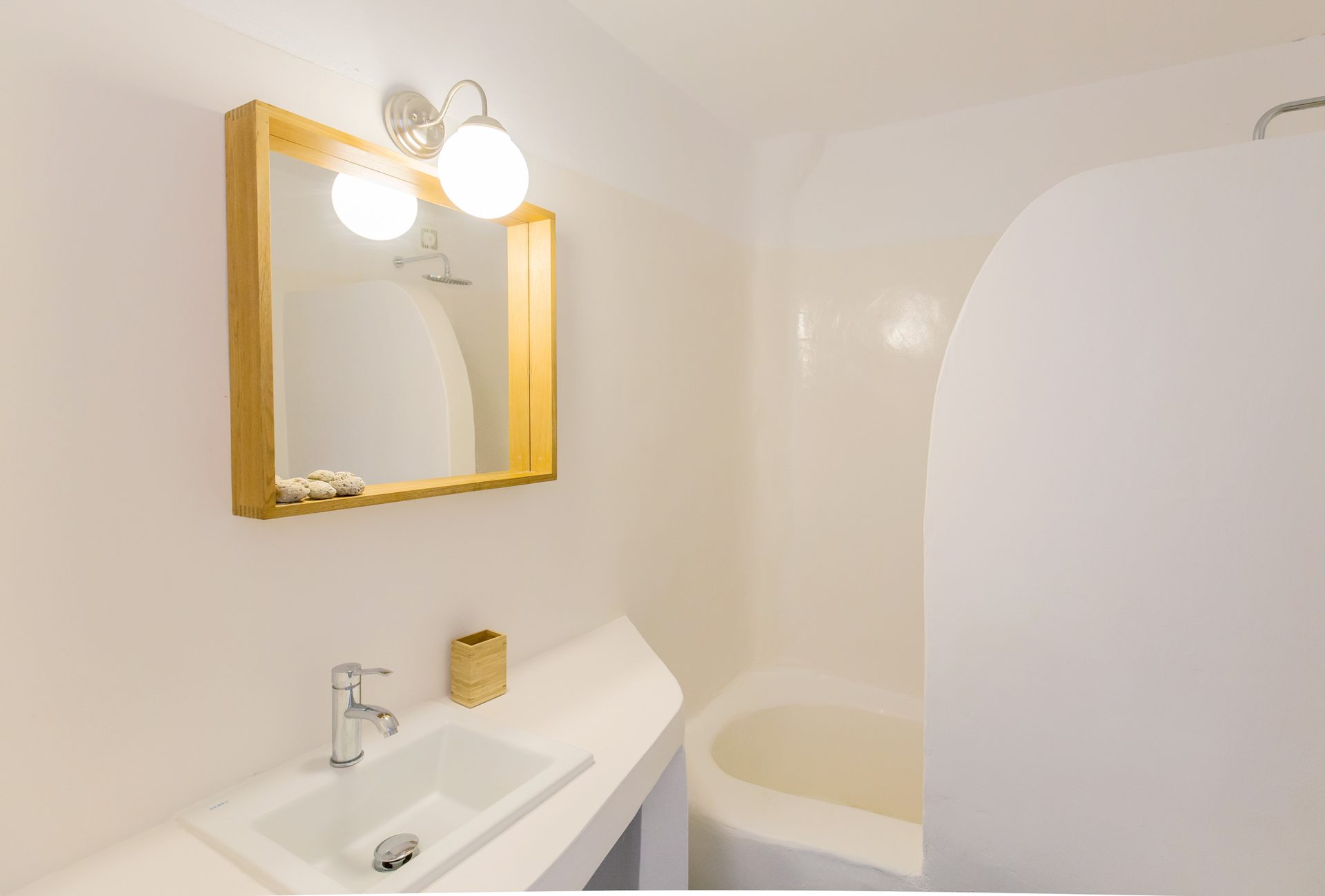 Bathroom with round mirror at Villa Phaedra in Pouli, Mykonos