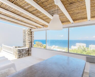Dining area with sea-view windows at Villa Phaedra in Pouli, Mykonos