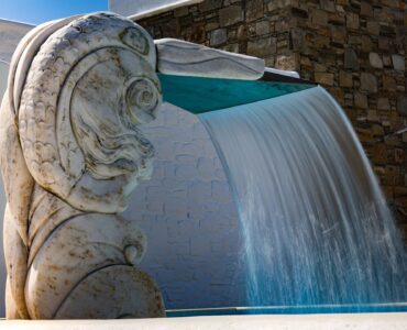 Stone water feature over the pool at Villa Uranos in Psarou, Mykonos