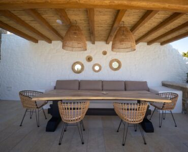 Outdoor dining under the wooden pergola at Villa Uranos in Psarou, Mykonos