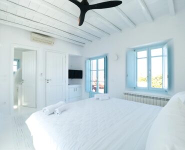 Double bedroom with blue windows at Villa Uranos in Psarou, Mykonos